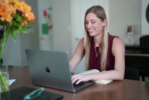 A smiling teacher studies for an online professional development program.